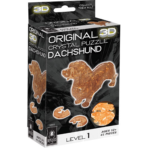 A 3D crystal jigsaw puzzle featuring a Dachshund in a vibrant amber color. The packaging shows the finished product alongside the puzzle pieces. Suitable for ages 12 and up, this puzzle has 41 pieces and is labeled as Level 1 difficulty.