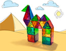 A vibrant 100-piece set of Magna Tiles in clear colors, arranged to create a colorful structure resembling a bird and a house. The tiles are geometric shapes, showcasing bright hues of green, red, blue, and yellow, set against a simple backdrop illustrating a desert with pyramids and a sun, emphasizing the creativity and educational potential of this DIY kit.