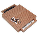 The Go Set w/drawers - 12" features a premium wooden game board with a grid pattern. It includes black and white stones stored in convenient drawers on the side, perfect for strategic gameplay. Ideal for both beginners and seasoned players, this elegant set enhances any game night with its classic design.